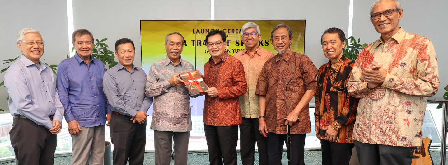 Nine people pose for a book launch event.